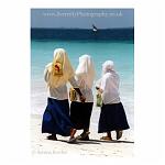 Schoolgirls walking along the beach in Zanzibar, Africa.